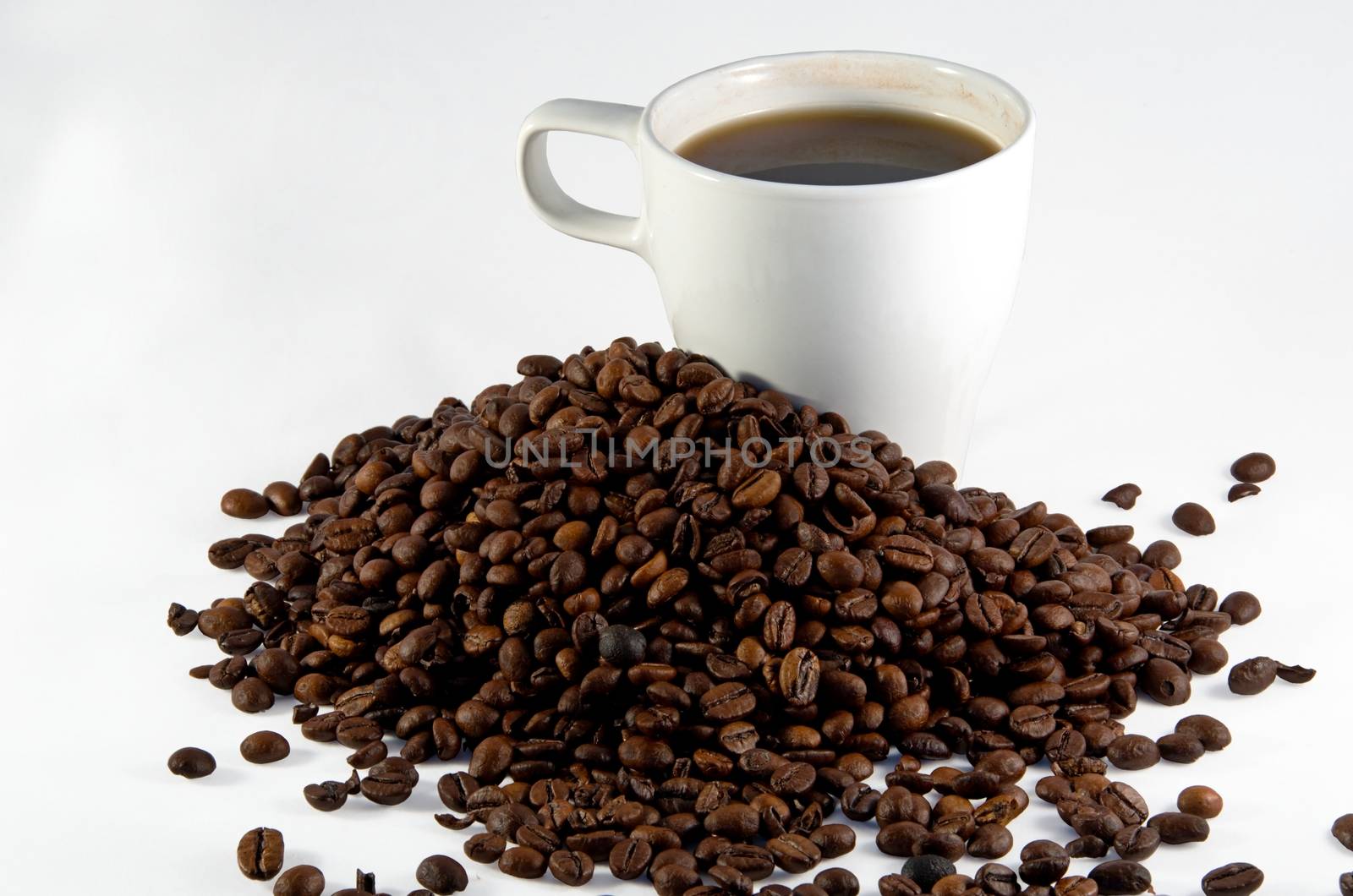 White cup with coffee and trowel of coffee beans