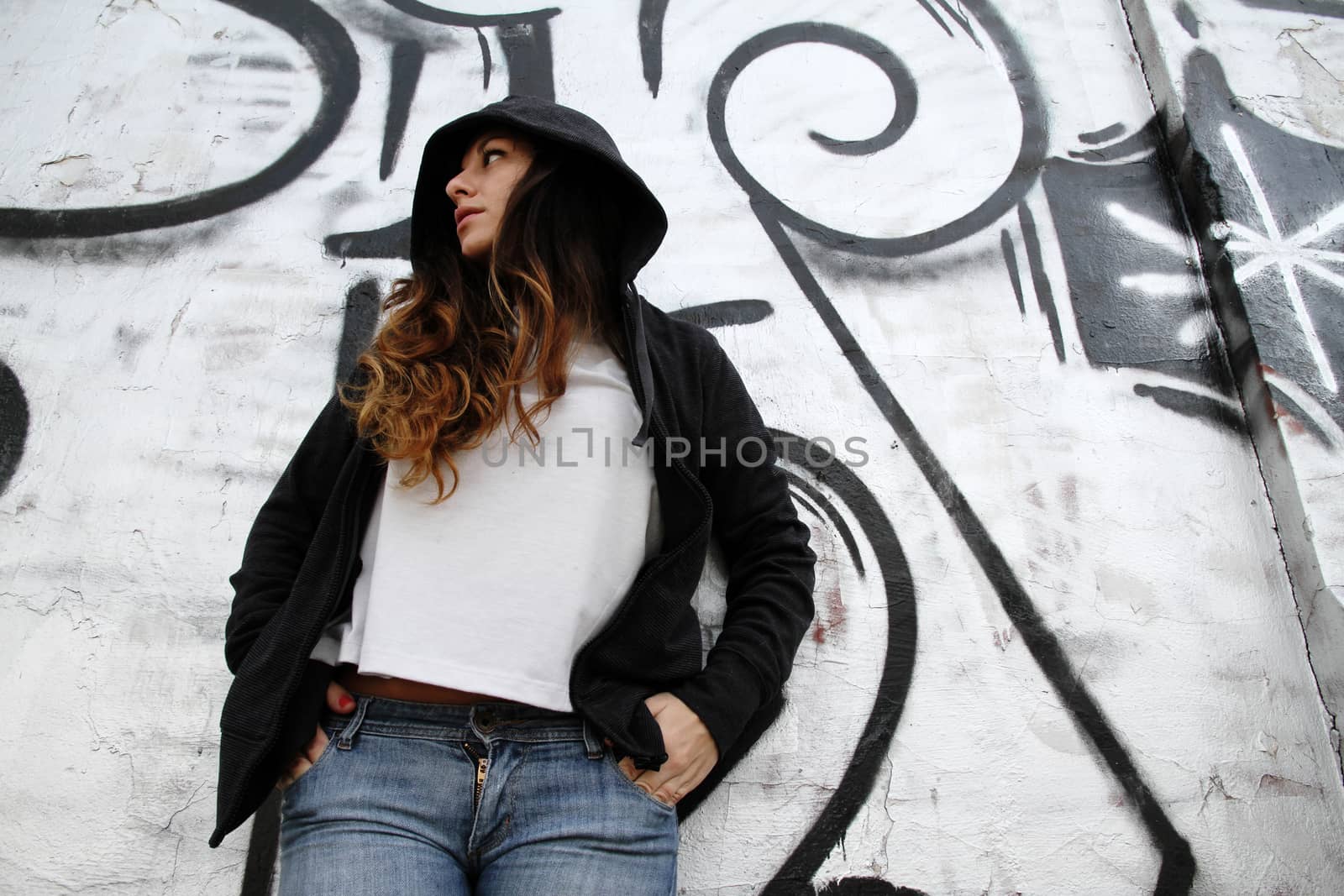 A young woman leaning on a wall.