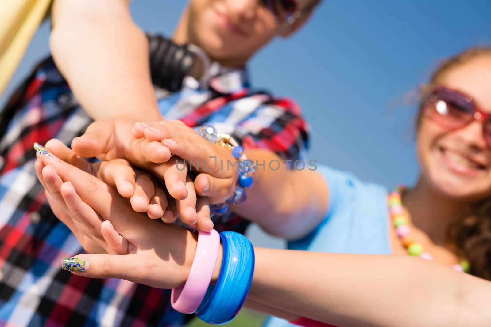 group of friends with arms folded in a column, teamwork