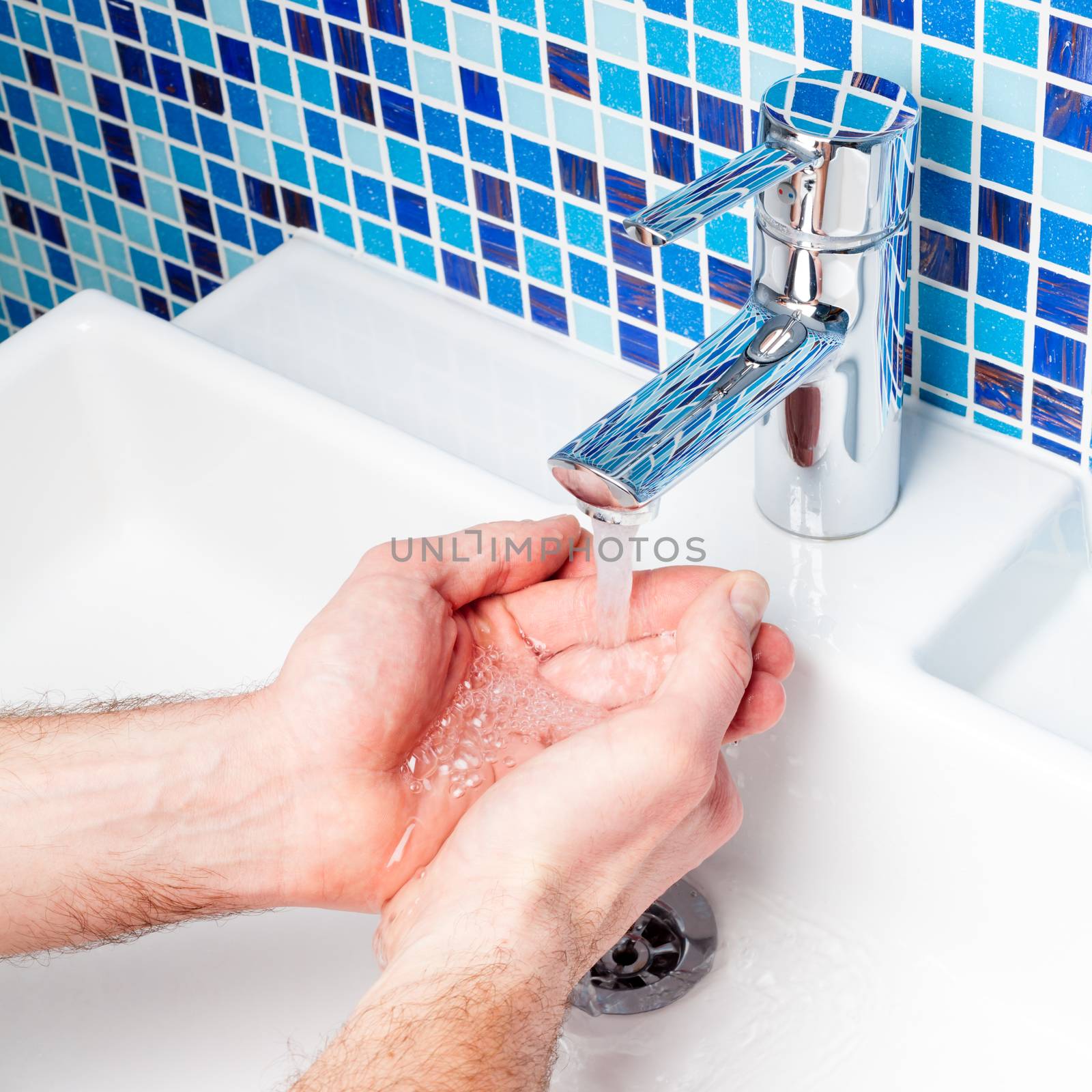 Man washing his hands in a bathroom sink