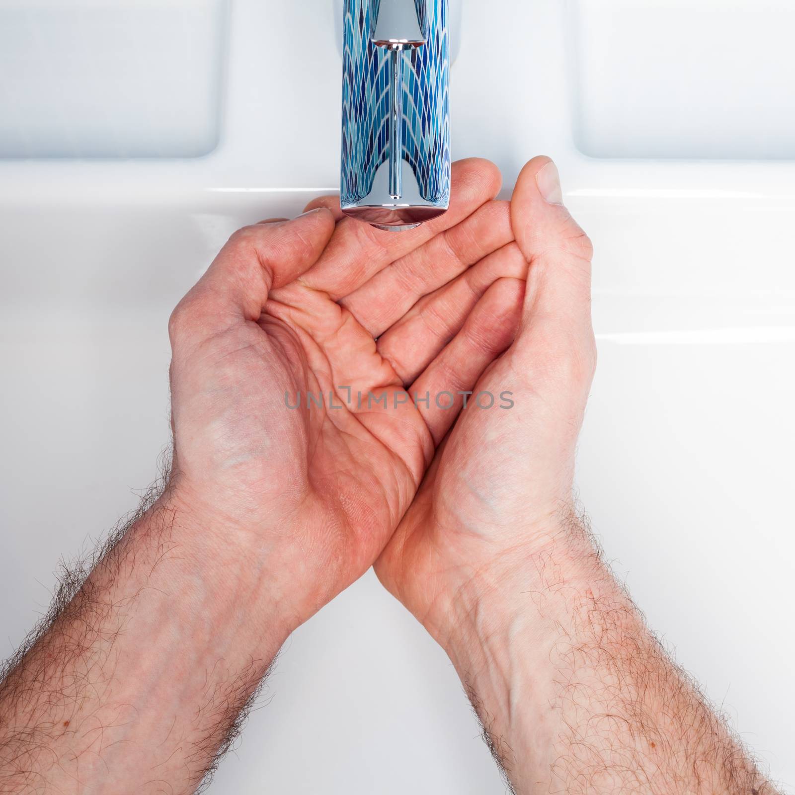 Man waiting to get water from bathroom sink