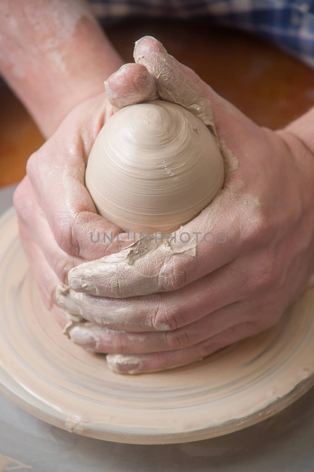 Hands of a potter, creating an earthen jar on the circle