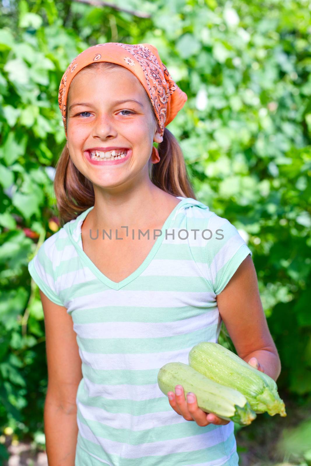 Cute girl with cabbages in summer garden