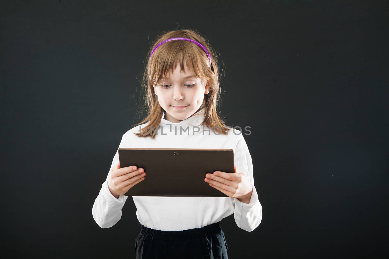 Portrait child with digital tablet on black background