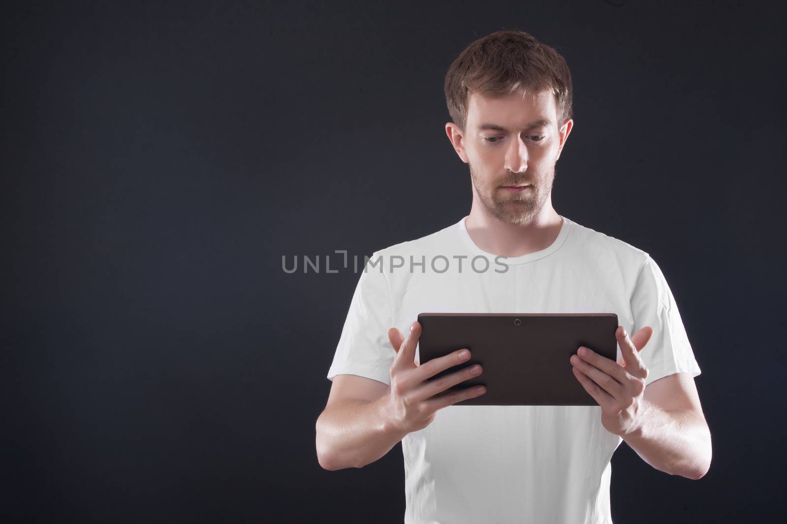 Portrait man with digital tablet on black background