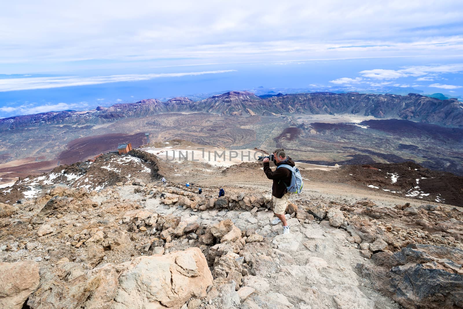 Man taking picture at top volcano Teide horizontal by Nanisimova