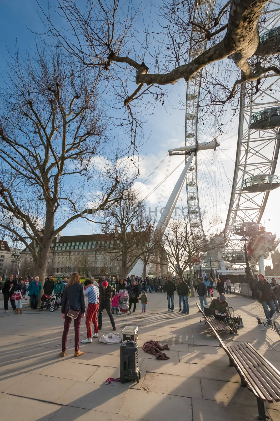 LONDON, UK  - JANUARY 27, 2013: Street performers entertaining tourists at sunset on the River Thames South Bank in London, UK