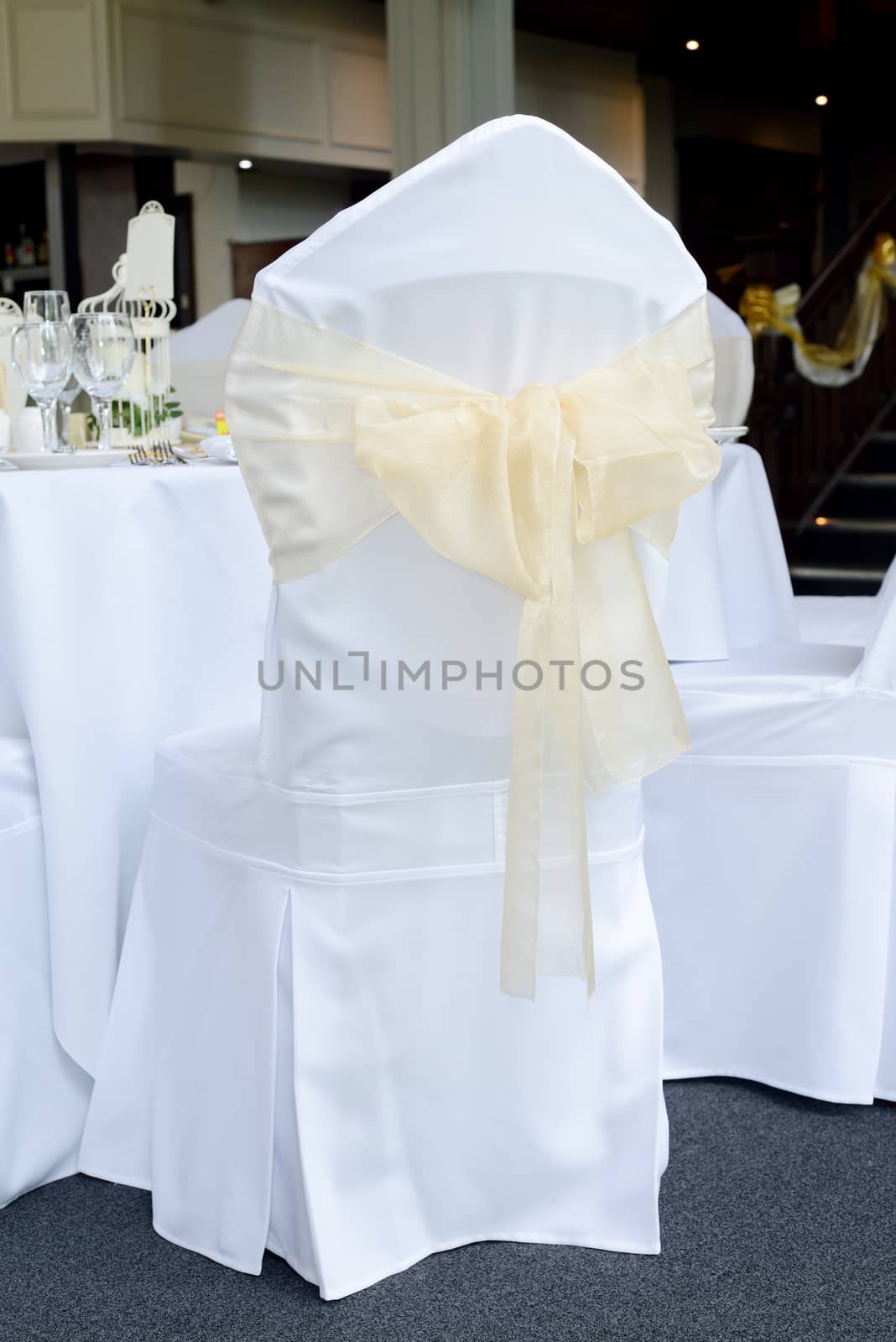 Wedding reception chair cover is white and gold or yellow