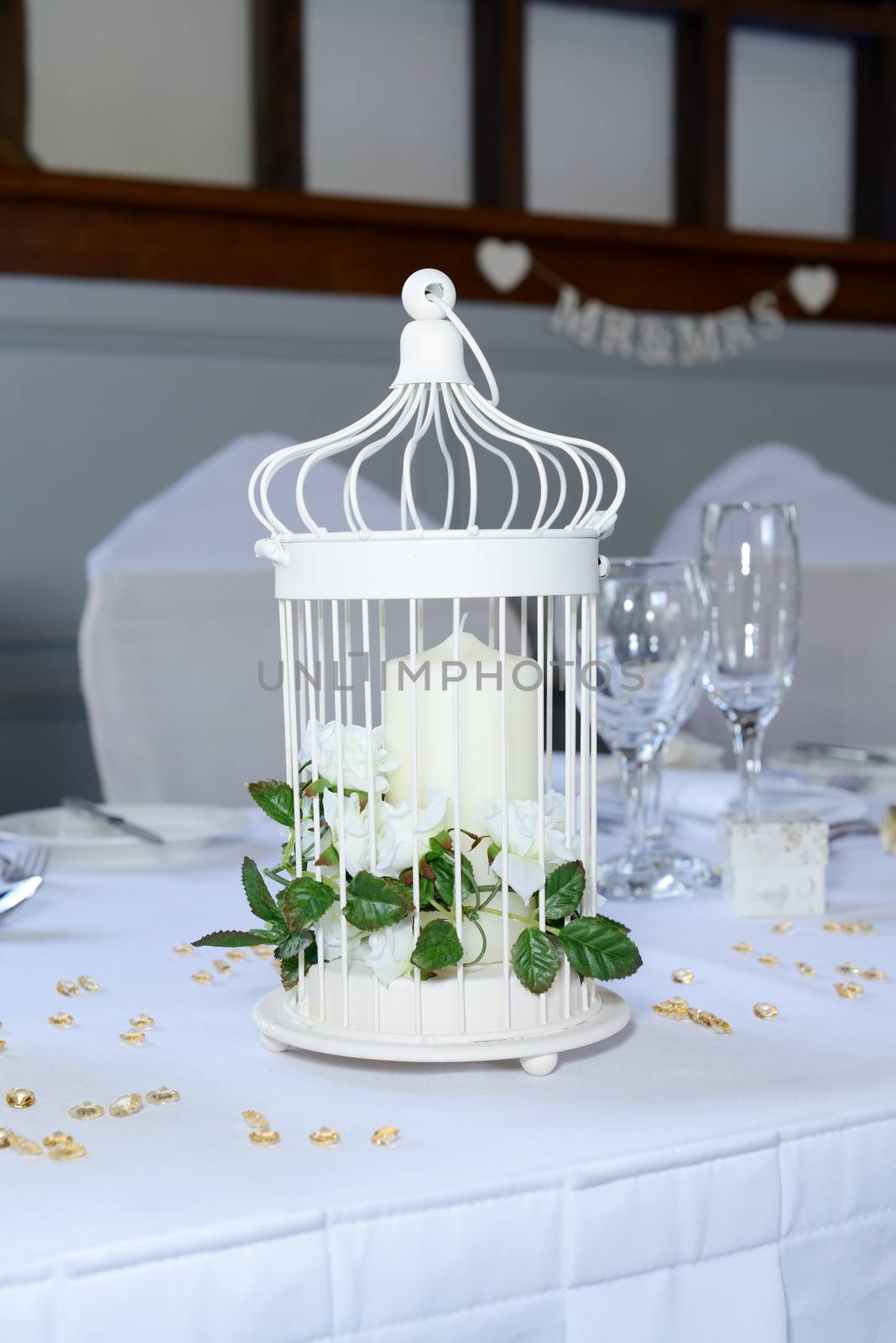 Wedding reception table closeup with details and decorations including cadle and white flowers