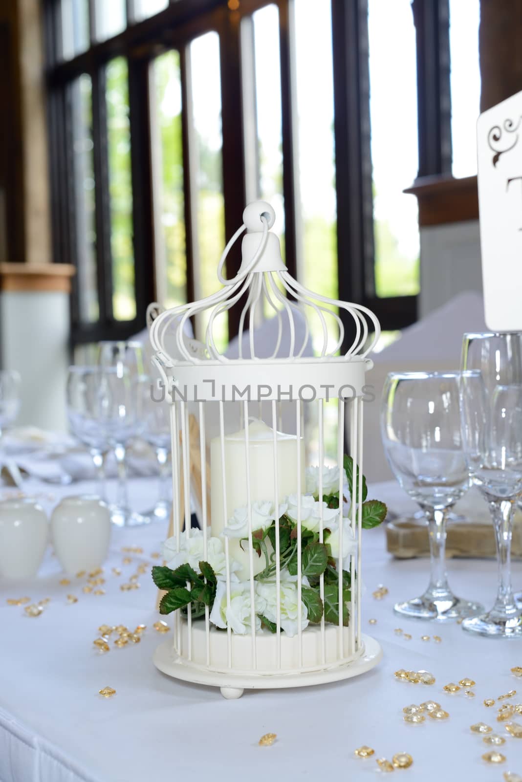 Wedding reception decoration of candle with white flowers on table closeup
