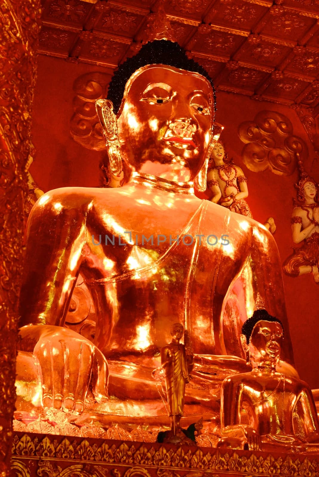 big buddha image that made by real gold at temple hall surrounding with angels,Lampang,Thailand