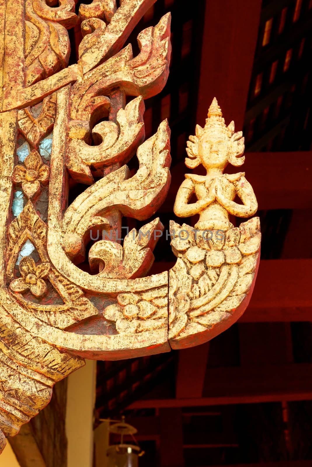 the detail of thai pattern ,show handmade wood carving work and decorated with gold plate,mirror and precious stone,Lampang temple,Thailand