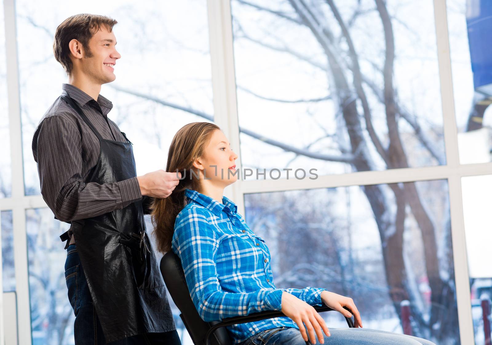 male hairdresser puts woman's hair in a hairdressing salon