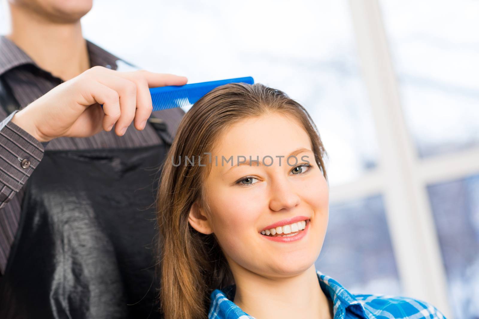 male hairdresser puts woman's hair in a hairdressing salon