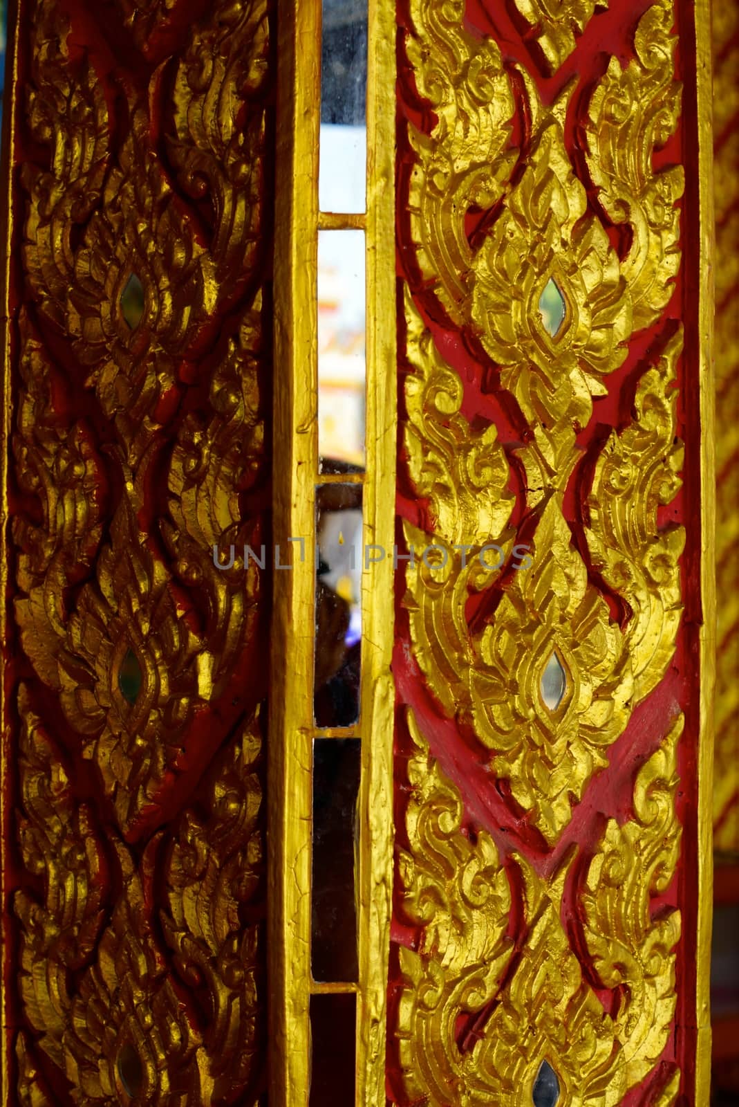 the detail of ancient thai decorated pattern that include handcraft wood carving work,gold painting and decorated with gold plate,mirror and precious stone,Lampang temple,Thailand