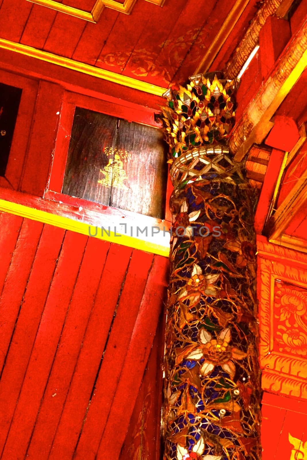 the detail of ancient thai decorated pattern that include handcraft wood carving work,gold painting and decorated with gold plate,mirror and precious stone,Lampang temple,Thailand