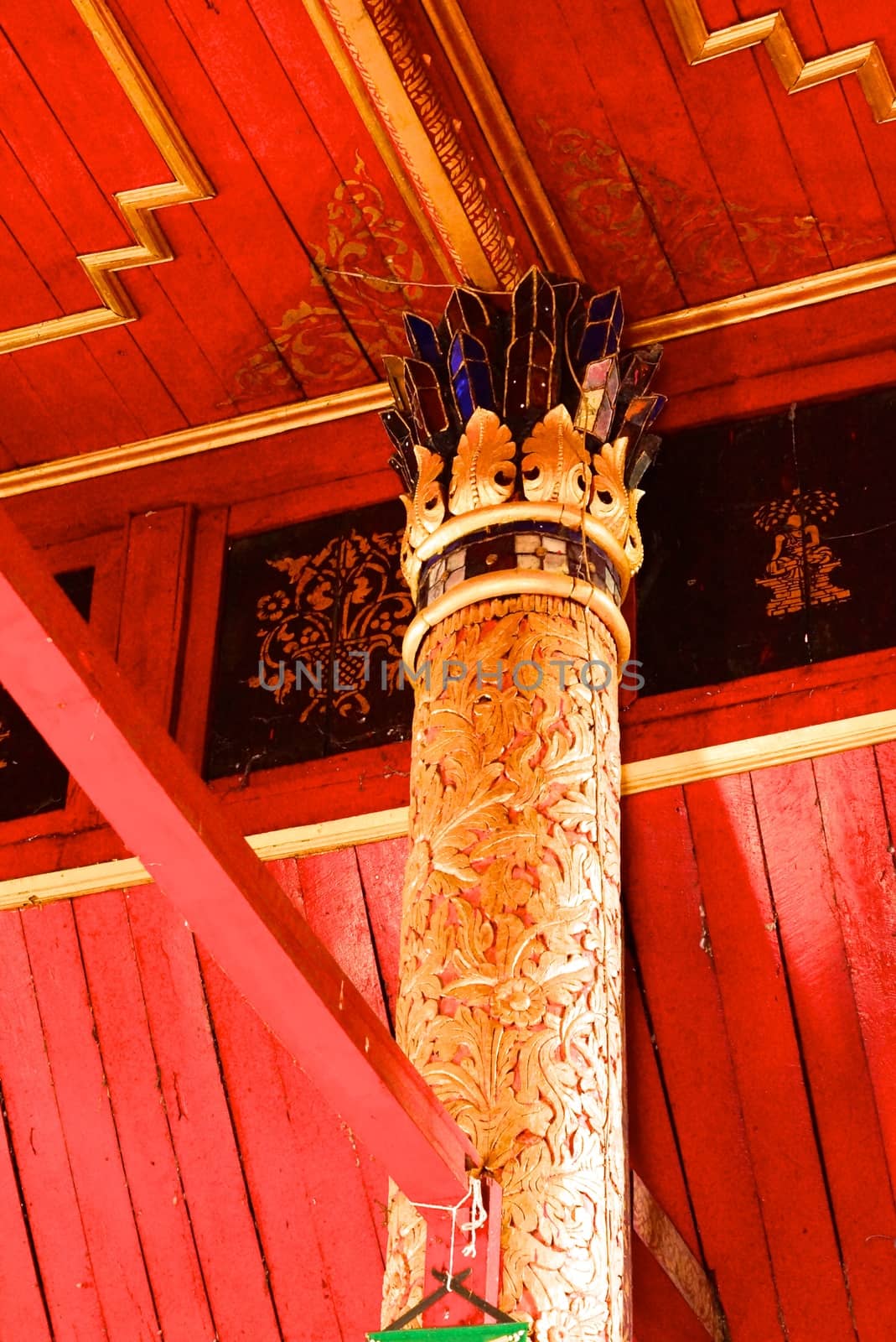 the detail of ancient thai decorated pattern that include handcraft wood carving work,gold painting and decorated with gold plate,mirror and precious stone,Lampang temple,Thailand