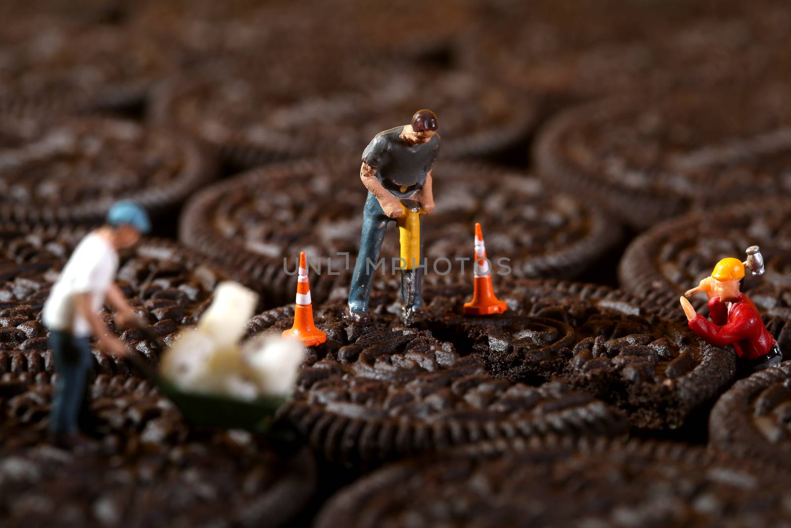 Miniature Construction Workers in Conceptual Imagery With Cookies