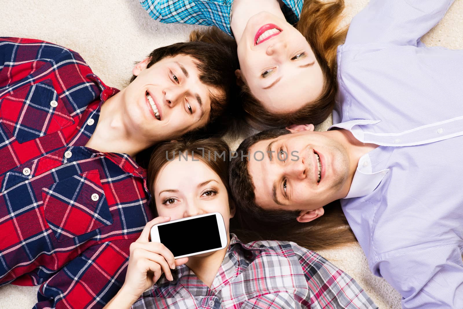 four young men lie together, young attractive woman pressed her lips to the phone