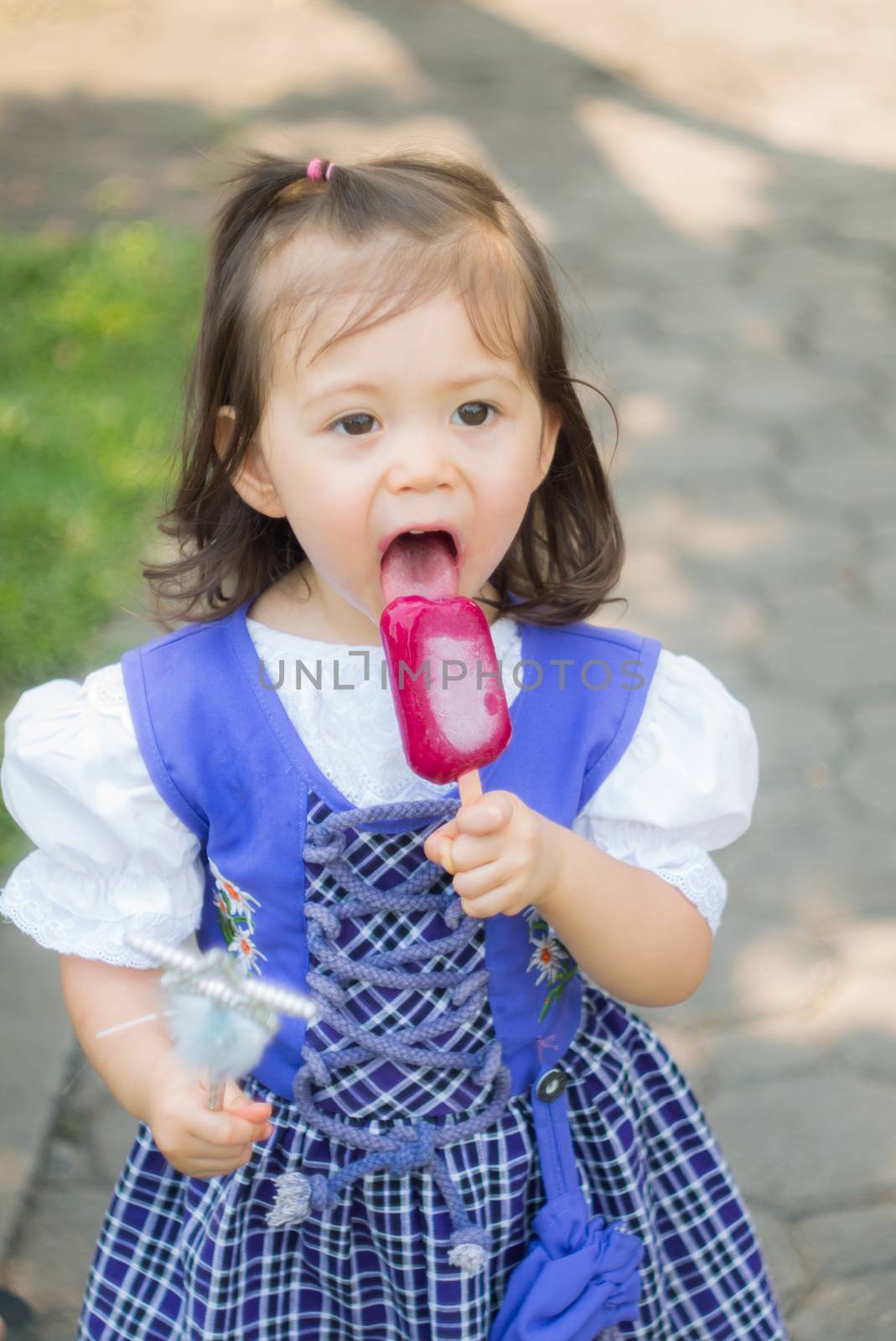 Adorable little cute girl eating icecream while holding wand