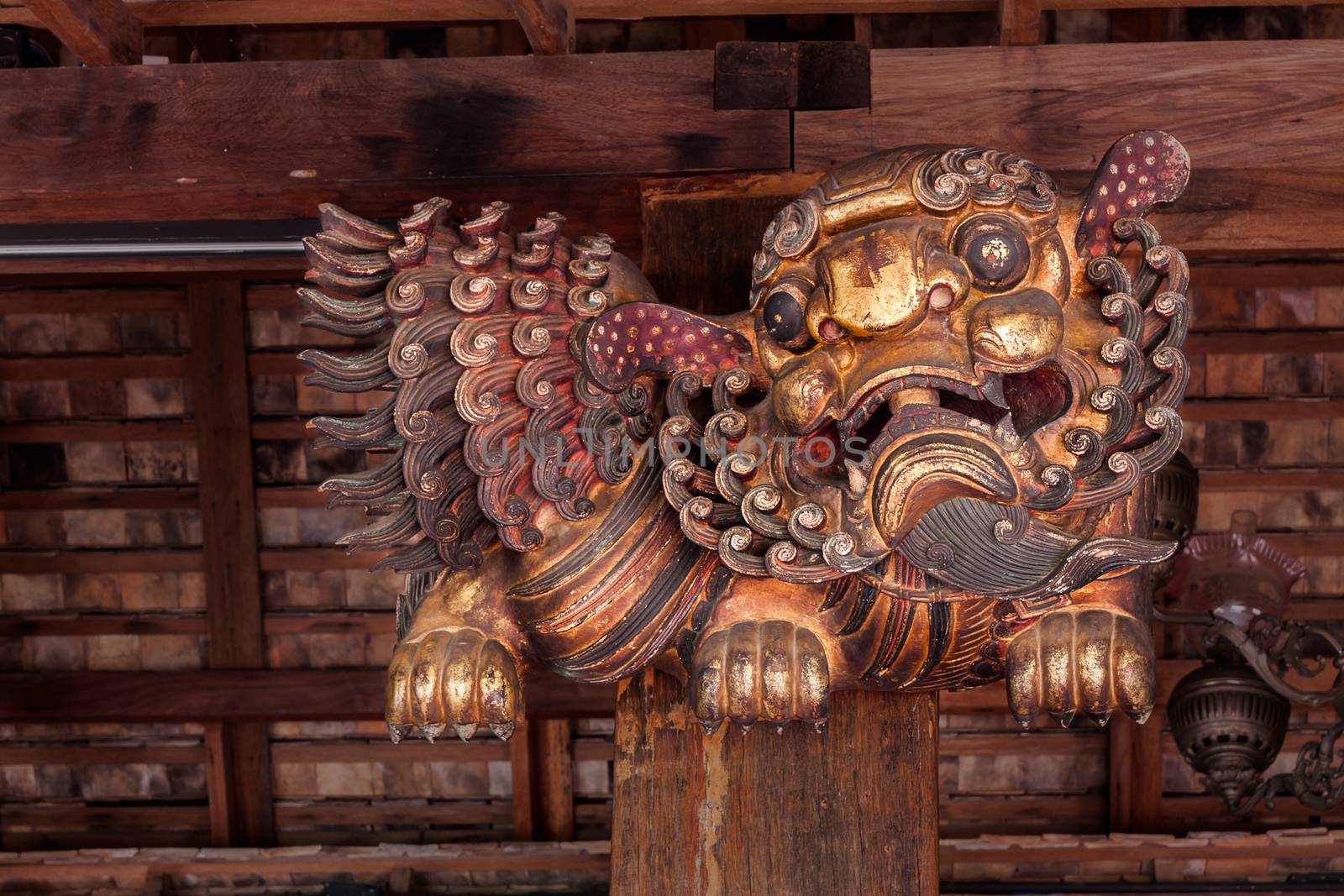 Chinese carving wooden lion decorated by stick to pillar