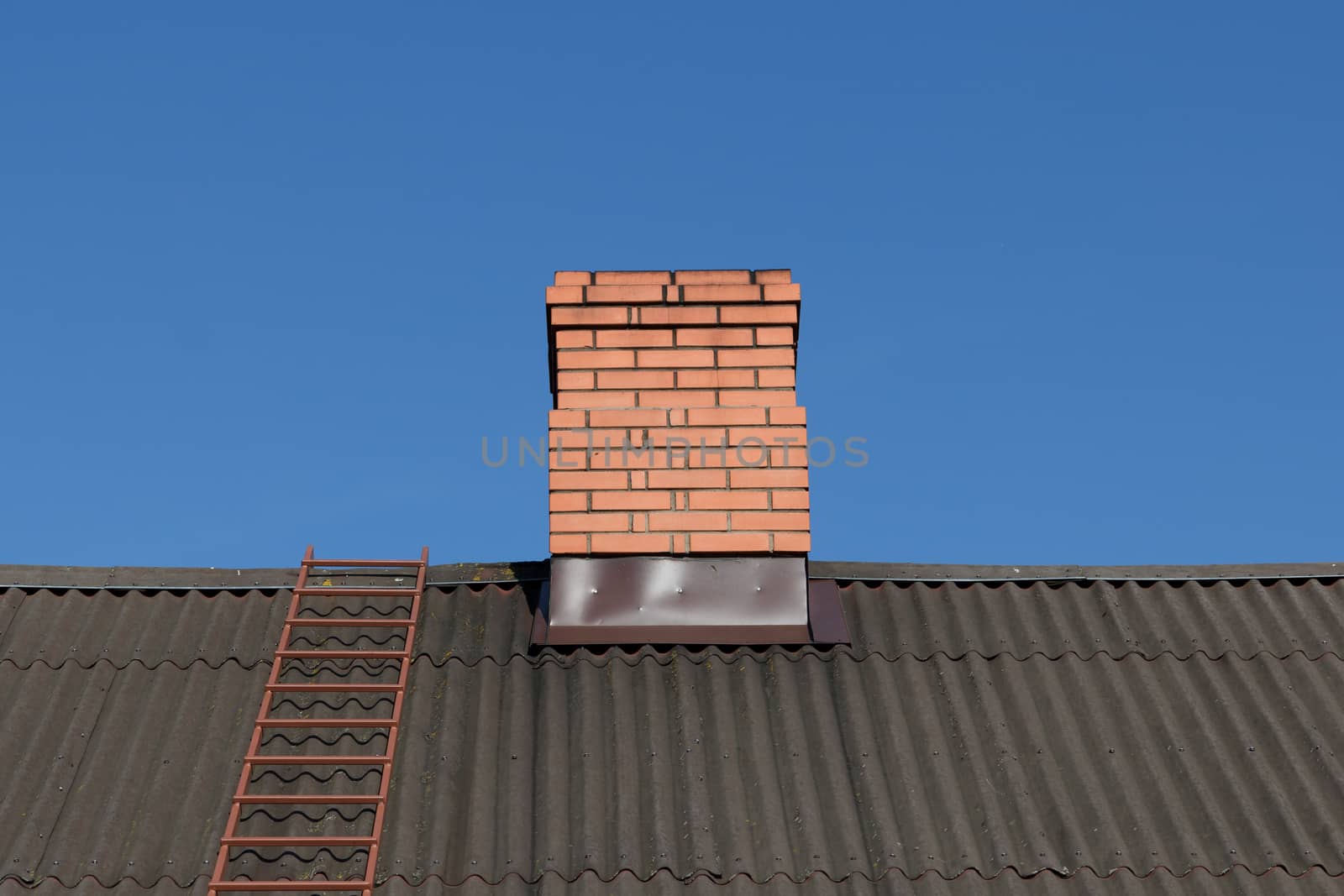red brick chimney against blue sky