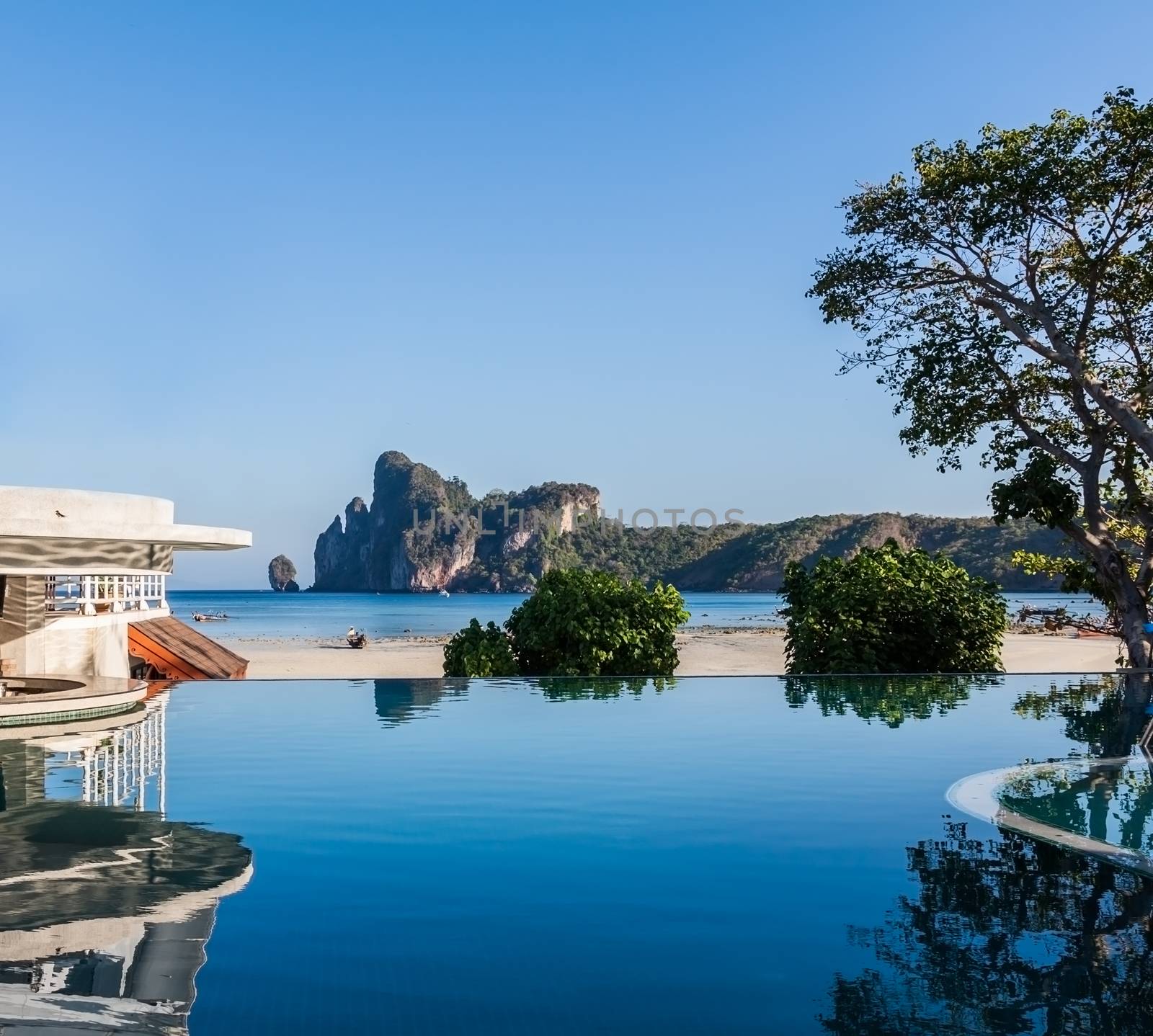 Swimming pool near beach with mountain view.