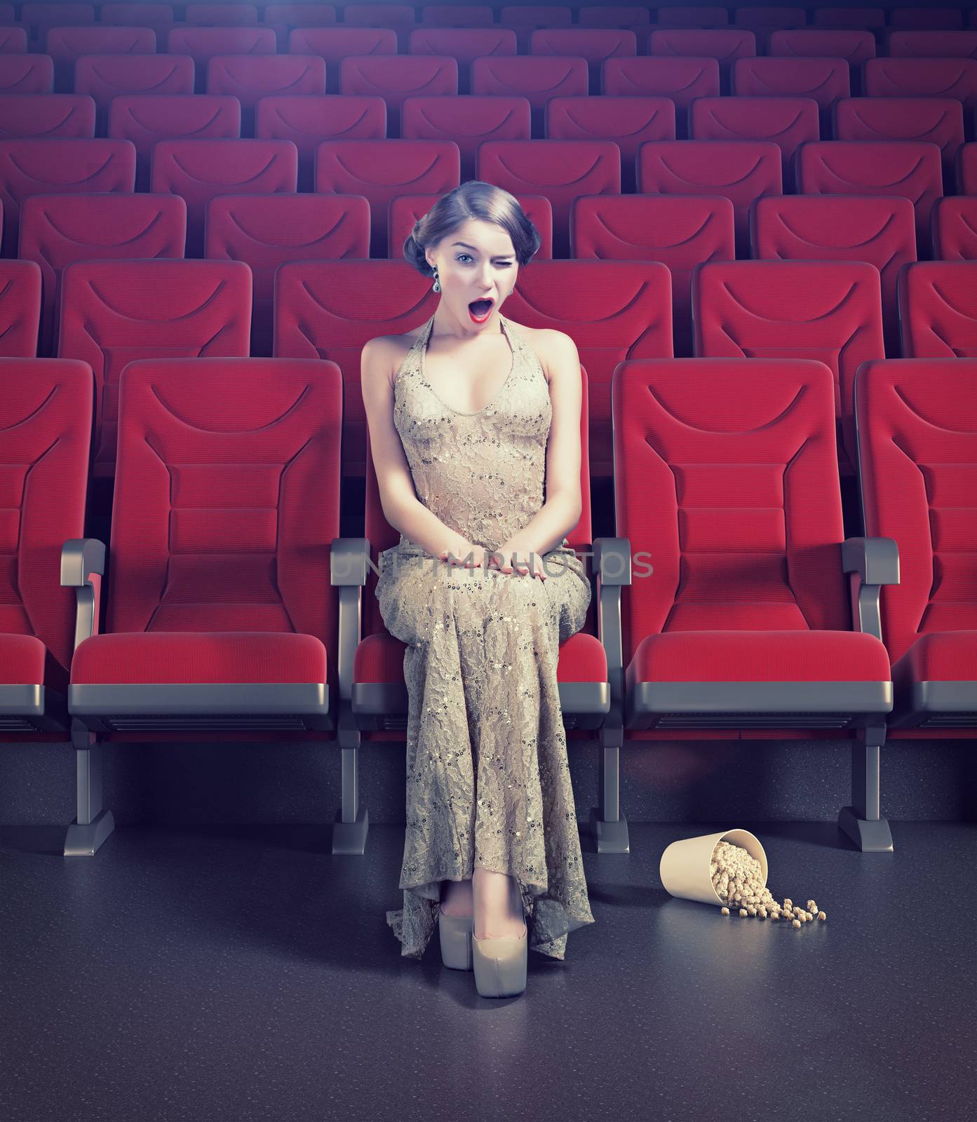 Surprised beautiful girl in an empty cinema. Creative concept