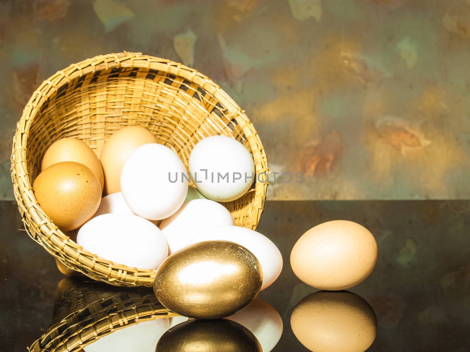 still life photography eggs in an inverted basket. golden egg.