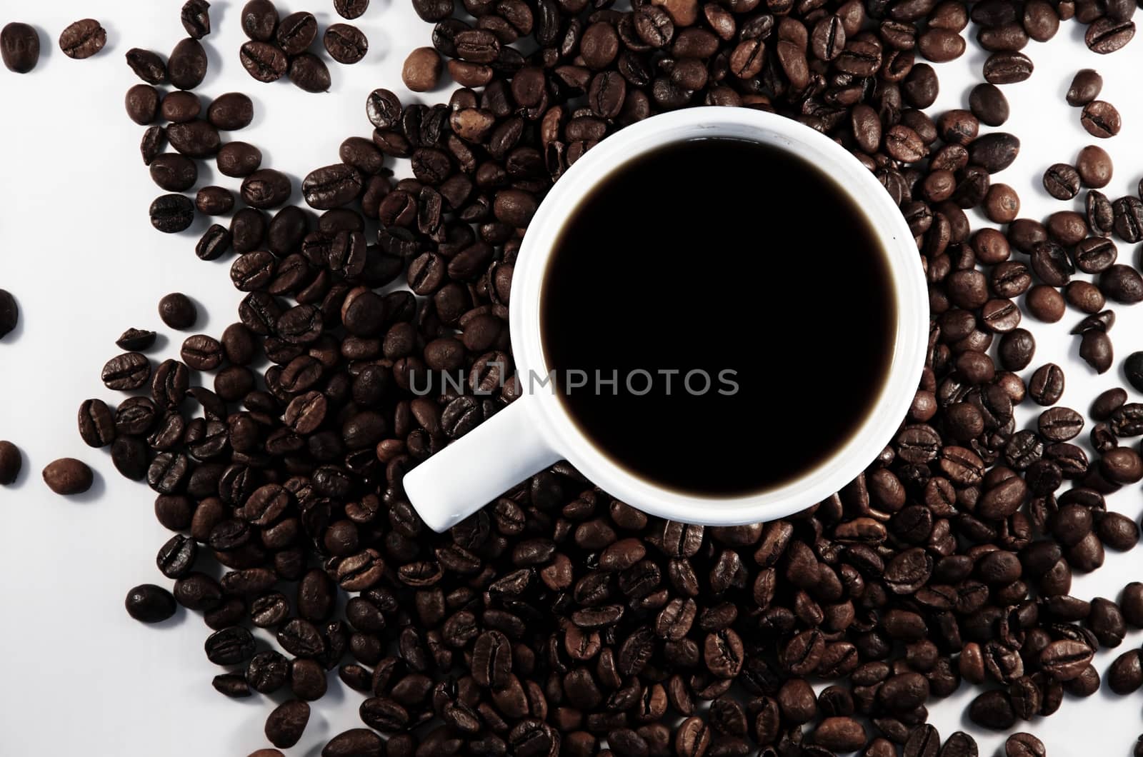 White cup with coffee and trowel of coffee beans