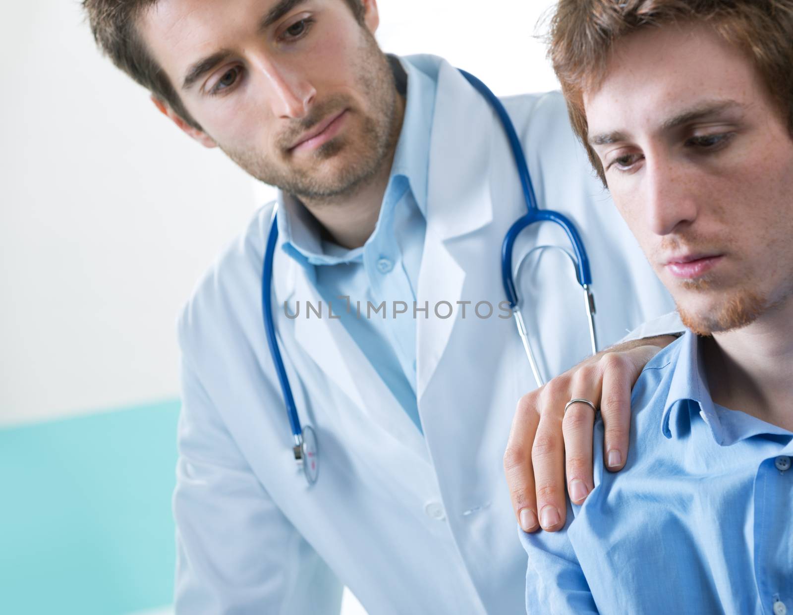 Doctor comforting a young patient after telling him bad news.