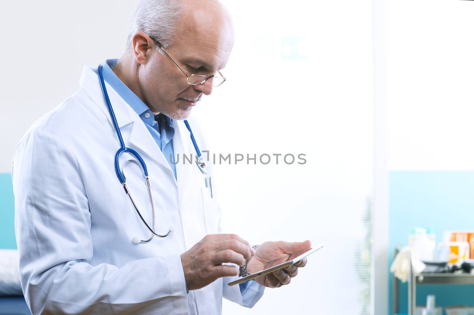 Senior doctor working with a tablet at the hospital.