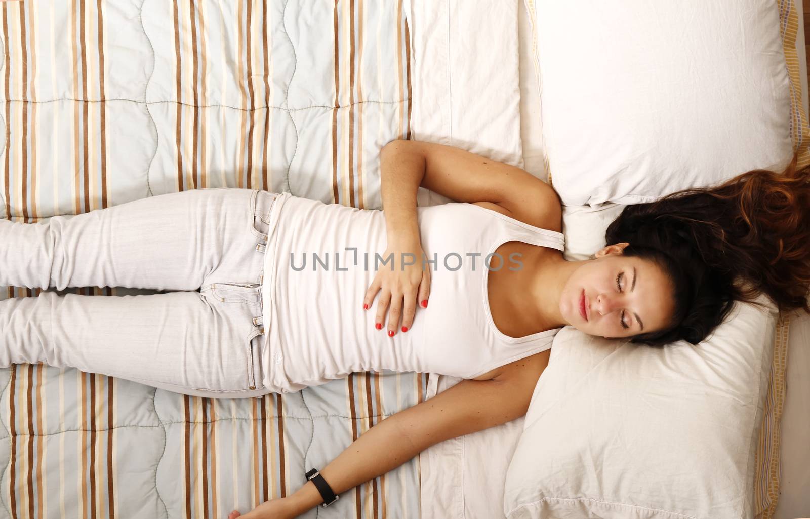 A sleeping young woman laying on the bed.