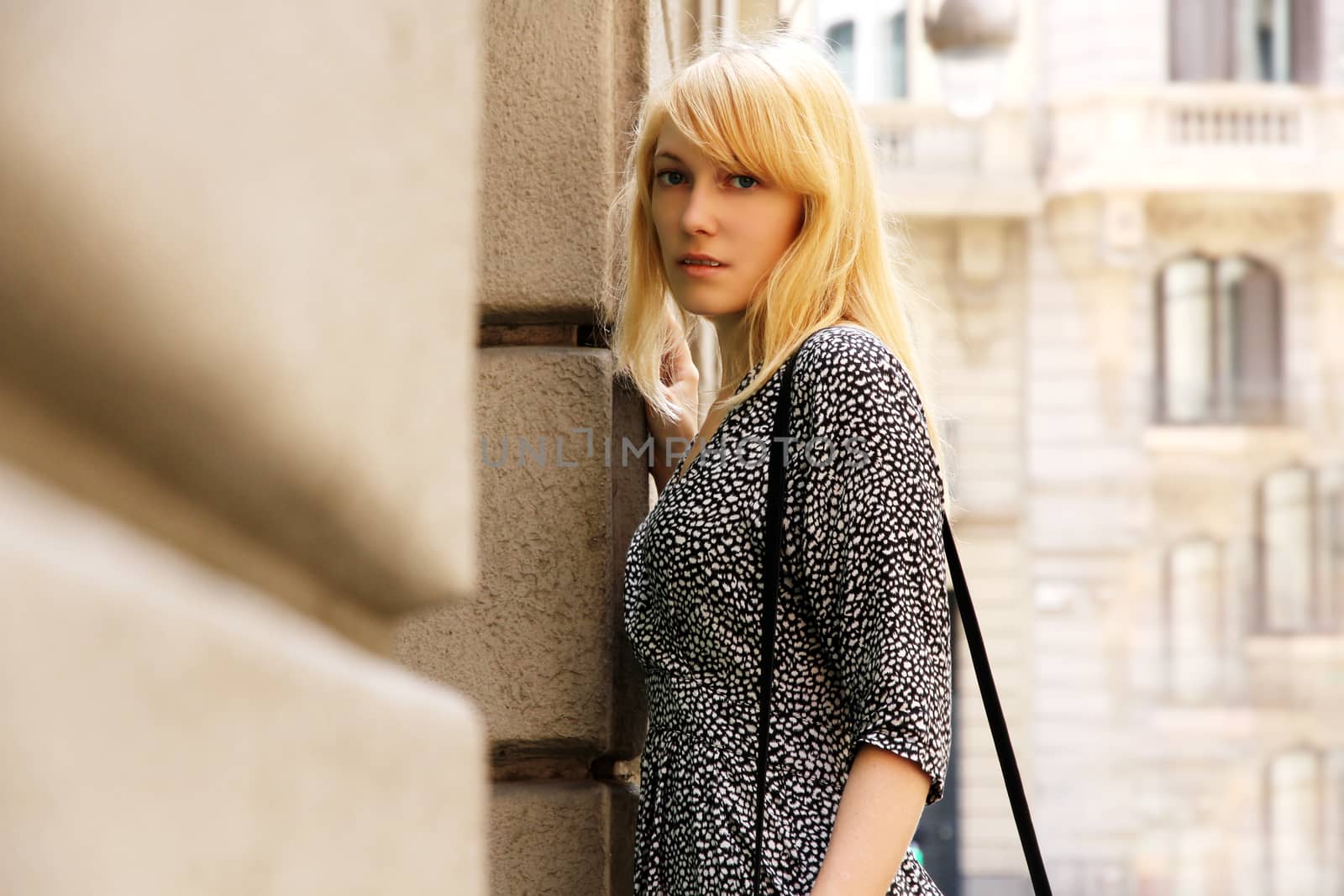 A young adult woman standing in front of a Store in downtown Barcelona, Spain.