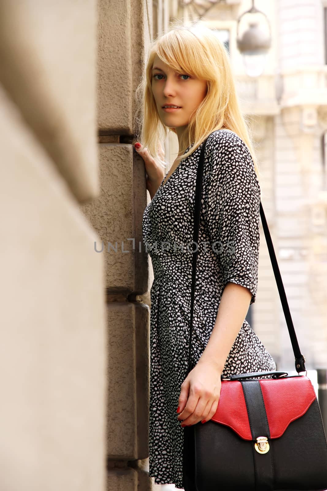 A young adult woman standing in front of a Store in downtown Barcelona, Spain.