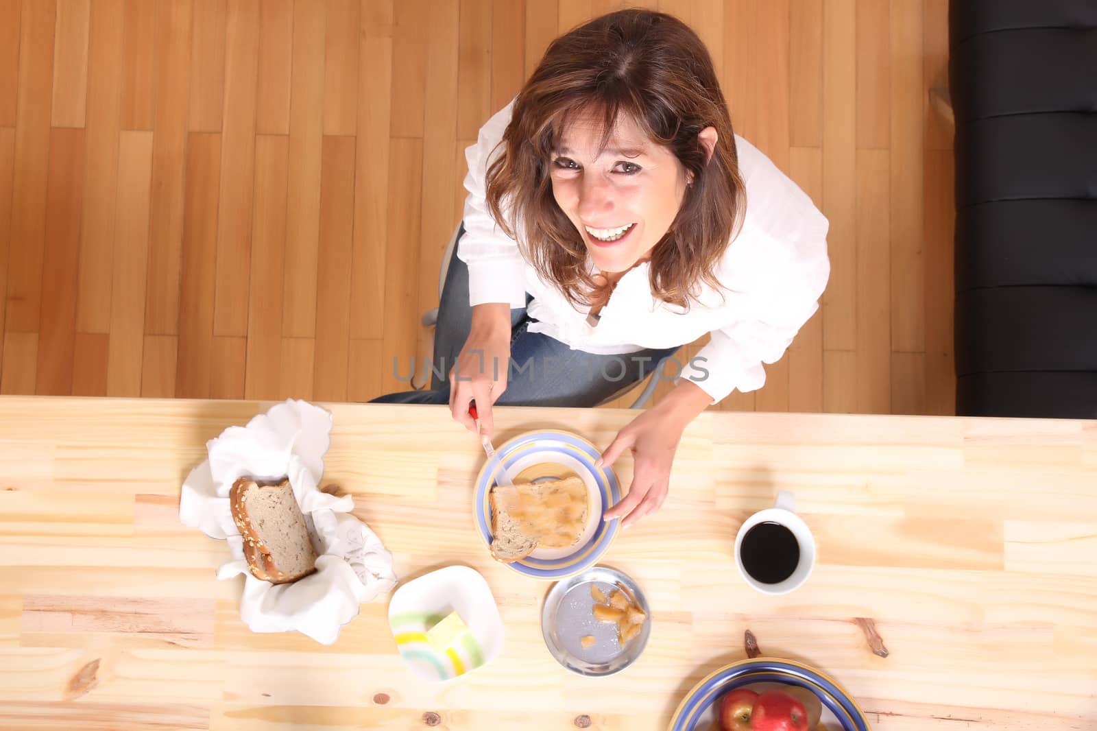 Portrait of a beautiful mature woman sitting in the kitchen. 