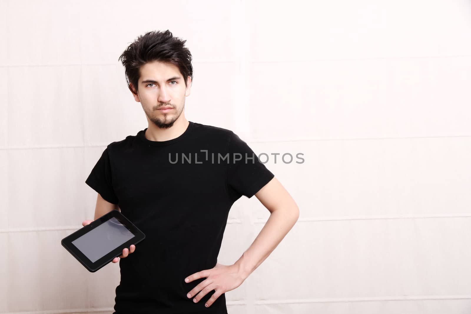 A young hispanic man holding a Tablet PC.