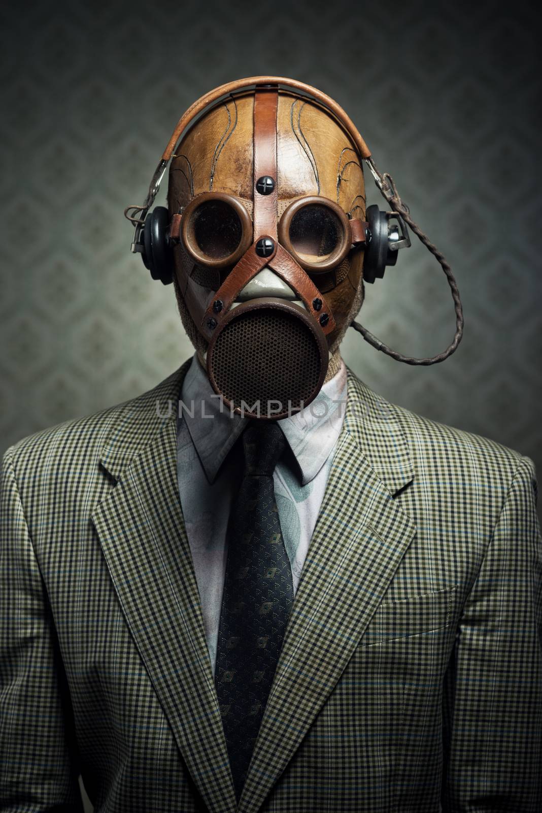 Man wearing vintage gas mask and headphones listening to music.