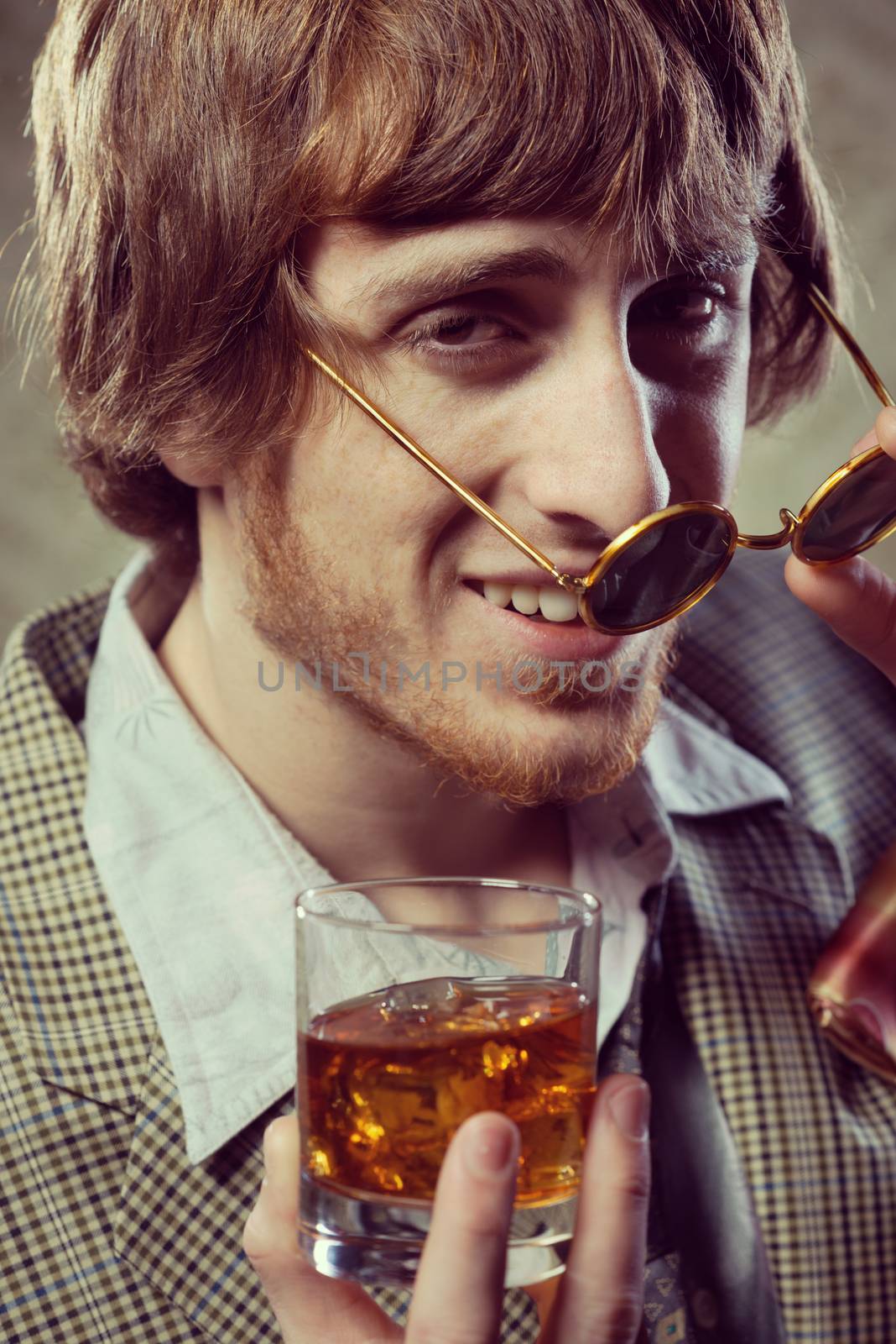 Funny guy holding a glass of whisky and posing 