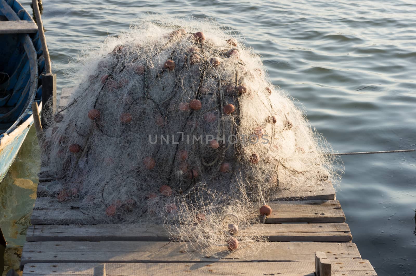 fishing net on the wooden jetty next to the boat