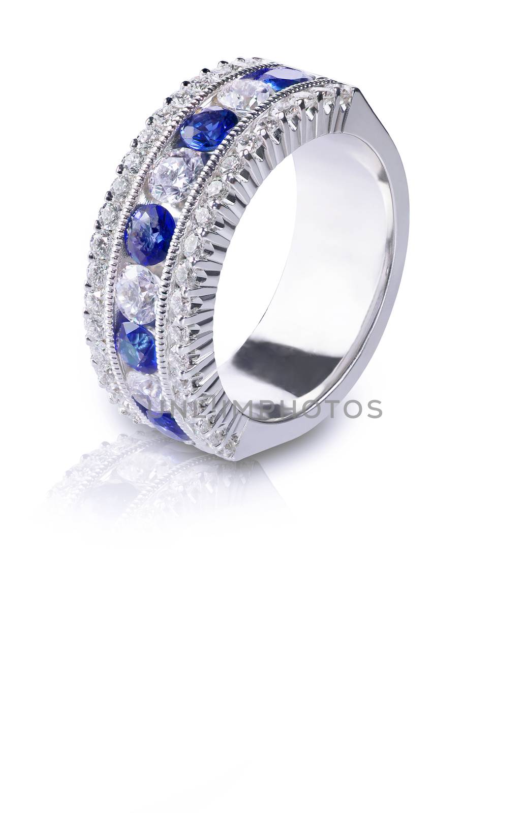 A blue Gemstone ring set in gold with diamonds. Isolated on white with a reflection.