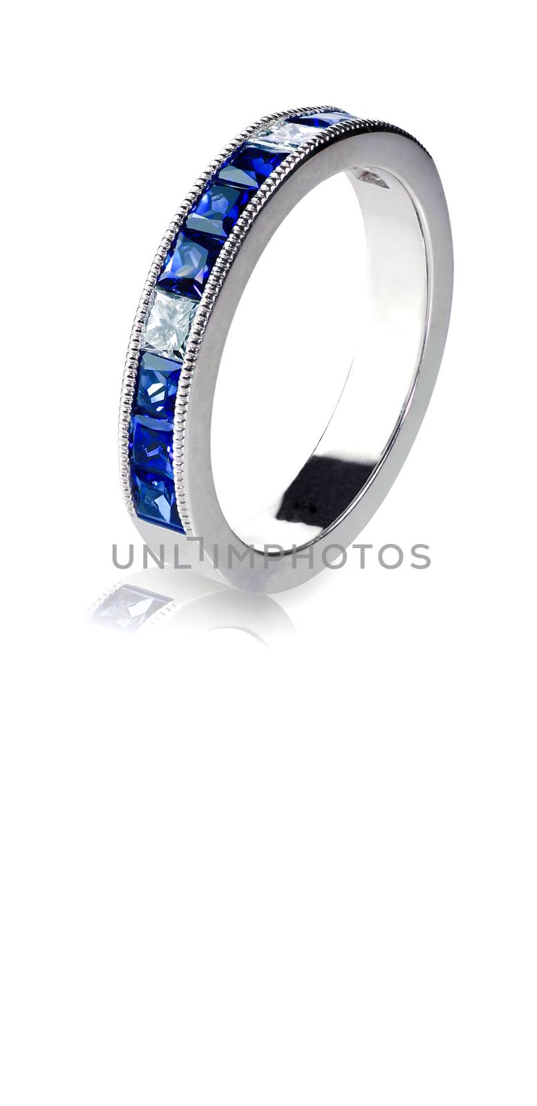 A blue Gemstone ring set in gold with diamonds. Isolated on white with a reflection.