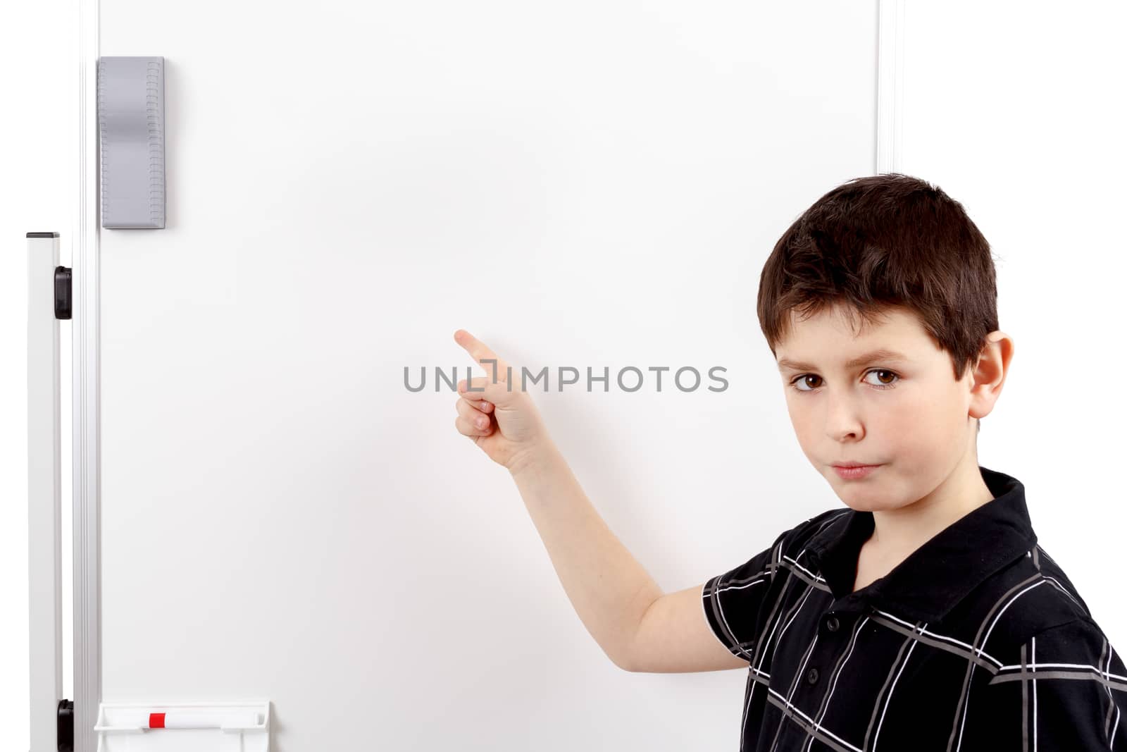 young boy student in a classroom showing on a empty white board