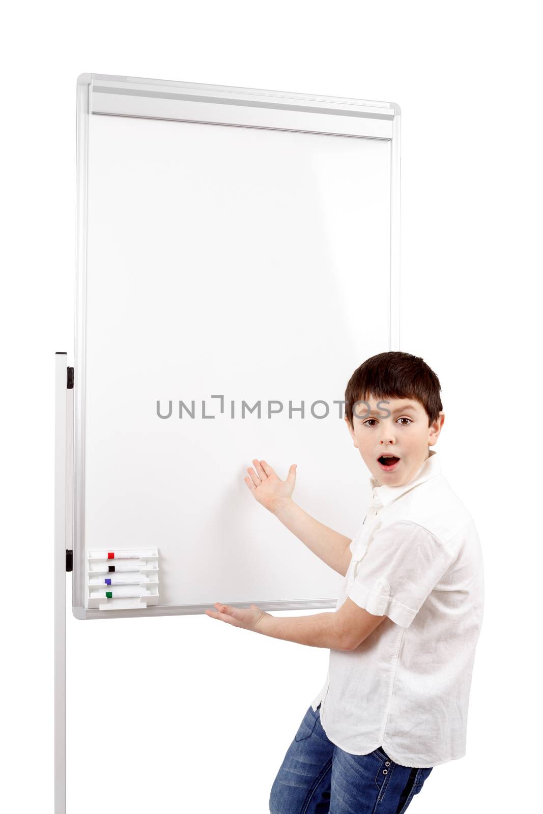 surprised young boy student in a classroom showing on a empty whiteboard