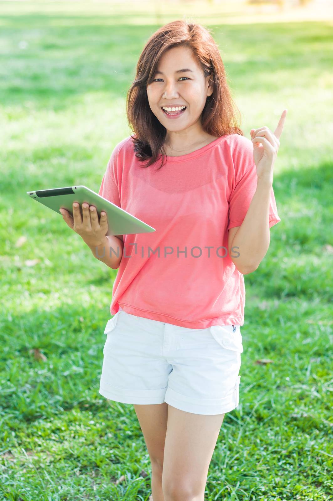 Happy Young Asian Woman Holding Digital Tablet and Smiling