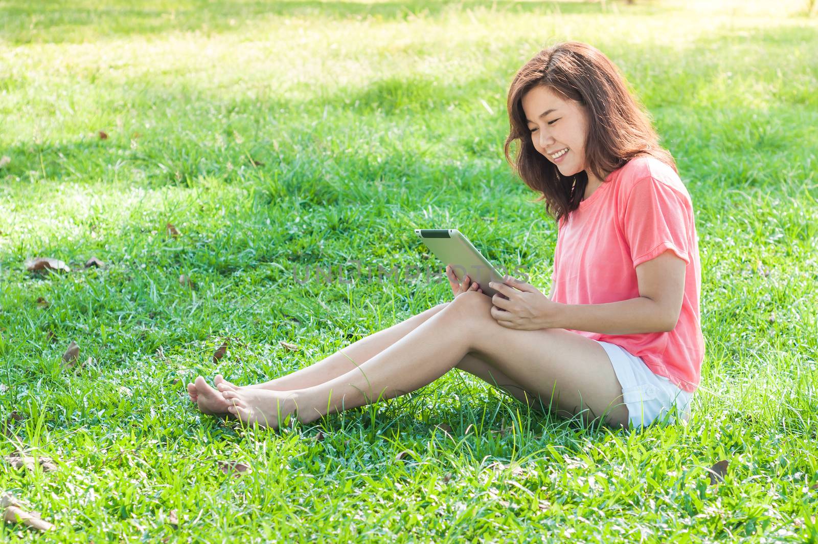 Happy Young Asian Woman Holding Digital Tablet and Smiling