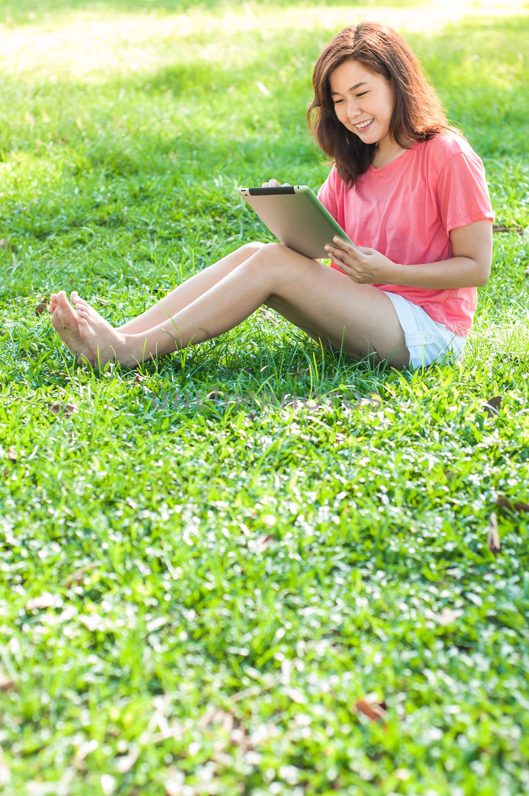 Happy Young Asian Woman Holding Digital Tablet and Smiling