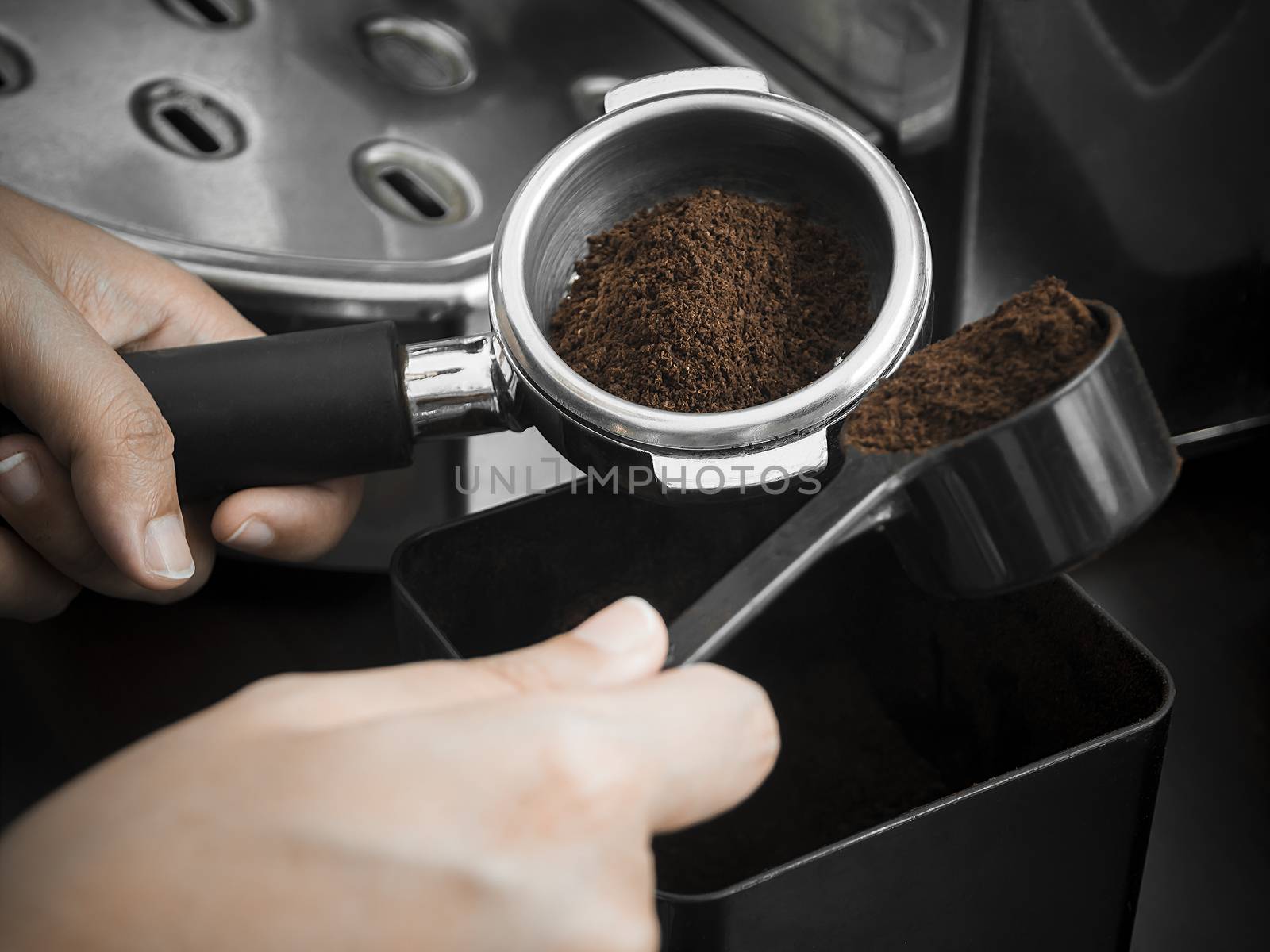 Barista holding portafilter with ground coffee