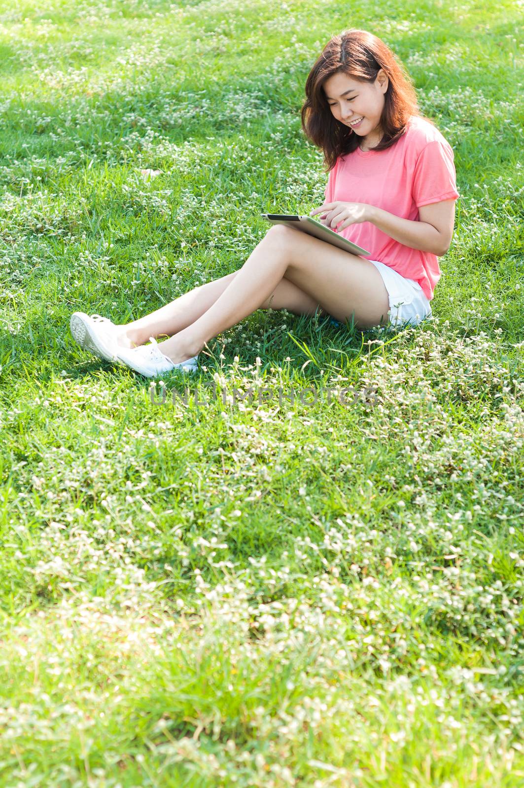 Happy Young Asian Woman Holding Digital Tablet and Smiling