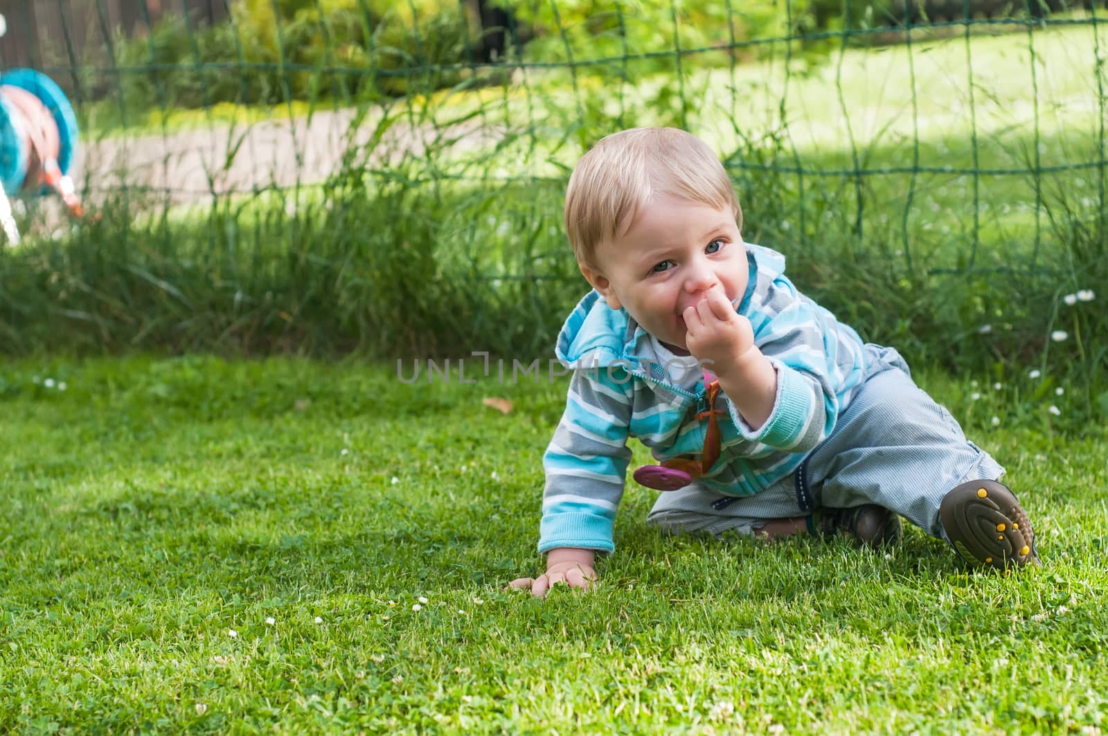 Shot of baby boy sitting on the green grass